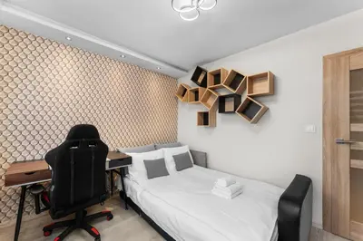 a bedroom with a desk and a bed and a chair at Nad Sudołem Homely Apartment by BookingHost in Kraków