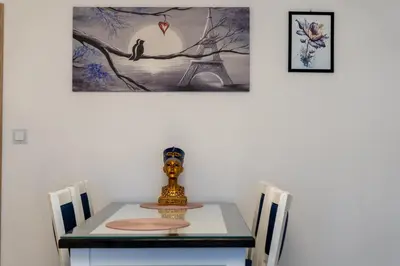 a dining room table with a bird on a tree branch at Nad Sudołem Homely Apartment by BookingHost in Kraków