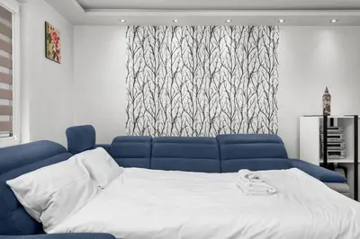 a bed in a room with a blue couch at Nad Sudołem Homely Apartment by BookingHost in Kraków