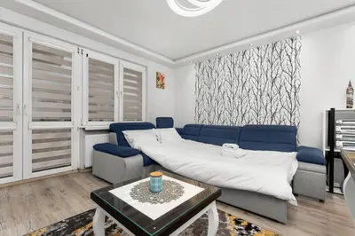 a living room with a couch and a table at Nad Sudołem Homely Apartment by BookingHost in Kraków