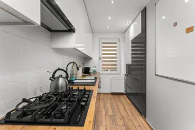 a kitchen with a stove with a tea kettle on it at Nad Sudołem Homely Apartment by BookingHost in Kraków