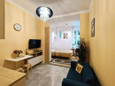 a living room with a couch and a clock on the wall at Apartament Kataryniarza in Kraków