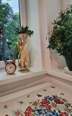 a room with a clock and a doll on a window sill at Apartament Kataryniarza in Kraków