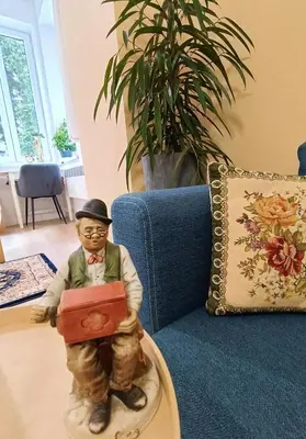 a figurine of a man holding a suitcase in a living room at Apartament Kataryniarza in Kraków