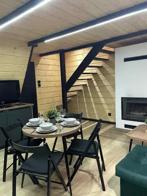 a table and chairs in a living room with a fireplace at Brda 5 osobowa z jacuzzi in Zawoja