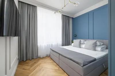 a bedroom with a large bed with blue walls at 4 Bedroom Apartment with Private Sauna and Parking in Kraków