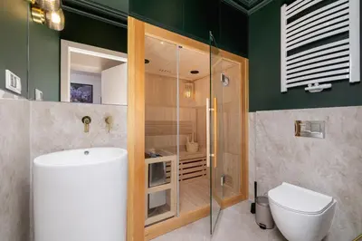 a bathroom with a shower and a toilet and a sink at 4 Bedroom Apartment with Private Sauna and Parking in Kraków