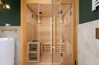 a shower with a glass door in a bathroom at 4 Bedroom Apartment with Private Sauna and Parking in Kraków