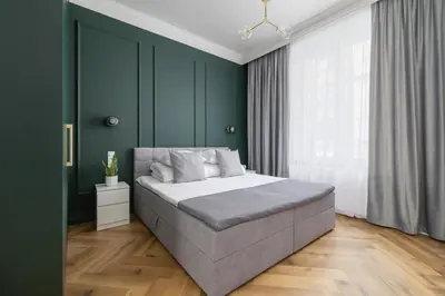 a bedroom with a large bed with green walls at 4 Bedroom Apartment with Private Sauna and Parking in Kraków