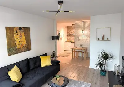 a living room with a black couch and yellow pillows at Old Town Retreat Cracow in Kraków