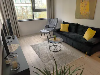 a living room with a black couch and a chair at Old Town Retreat Cracow in Kraków