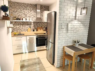 a kitchen with a stainless steel refrigerator and a table at Old Town Retreat Cracow in Kraków