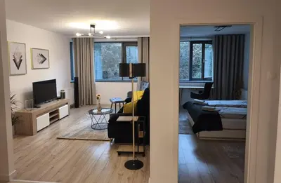 a living room with a couch and a bed and a television at Old Town Retreat Cracow in Kraków