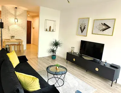 a living room with a black couch and a flat screen tv at Old Town Retreat Cracow in Kraków