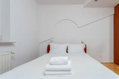 a bedroom with a white bed with towels on it at Pod Fortem Homely Apartment by BookingHost in Kraków