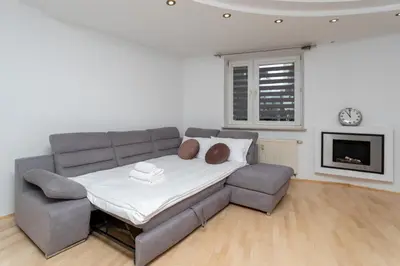 a couch and a chair in a living room at Pod Fortem Homely Apartment by BookingHost in Kraków