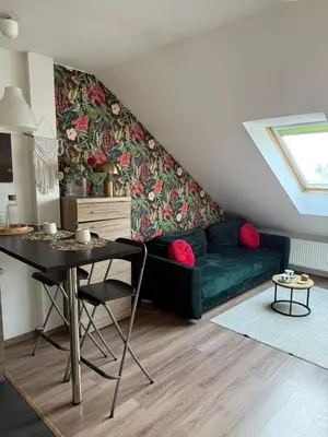 a living room with a green couch and a table at Vistula Apartment Kazimierz Old Town in Kraków