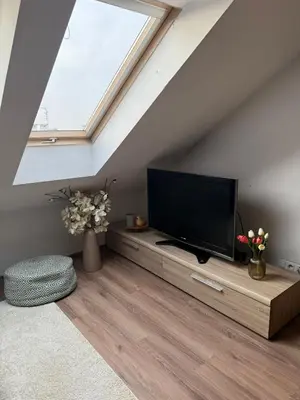 a living room with a flat screen tv in a attic at Vistula Apartment Kazimierz Old Town in Kraków