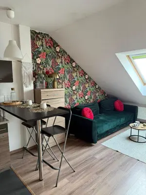 a living room with a green couch and a table at Vistula Apartment Kazimierz Old Town in Kraków
