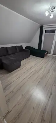 a living room with a couch and a wooden floor at W Rabczańskiej Dolinie 2 in Rabka