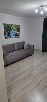 a living room with a couch and a wooden floor at W Rabczańskiej Dolinie 2 in Rabka
