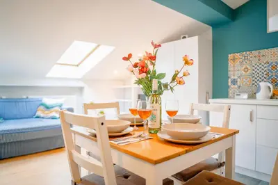 a dining room table with a vase of flowers on it at Podgórze Studio - Air Con, Workdesk, Castle Nearby in Kraków