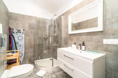 a bathroom with a shower and a toilet and a sink at Podgórze Studio - Air Con, Workdesk, Castle Nearby in Kraków