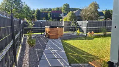 a backyard with a fence and a dog in the yard at Relaks Nad Potokiem in Sidzina