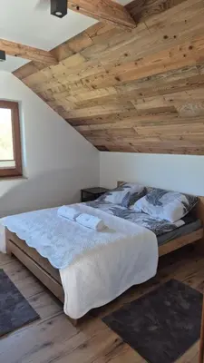 a bedroom with a bed with a wooden ceiling at Relaks Nad Potokiem in Sidzina