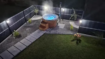 a backyard with a hot tub in the yard at night at Relaks Nad Potokiem in Sidzina