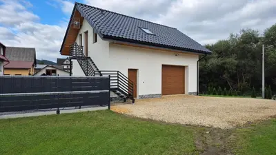 a white house with a black roof at Relaks Nad Potokiem in Sidzina