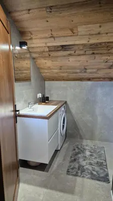 a bathroom with a washing machine and a sink at Relaks Nad Potokiem in Sidzina