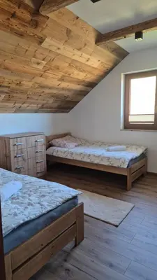 two beds in a room with wooden ceilings at Relaks Nad Potokiem in Sidzina