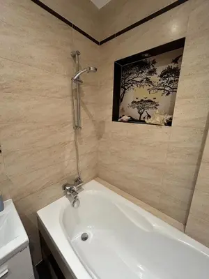 a white bath tub in a bathroom with a picture on the wall at Garden Spot and Parking in Kraków