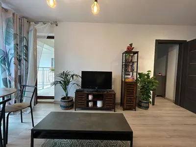 a living room with a tv and a table at Garden Spot and Parking in Kraków