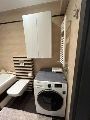 a bathroom with a washing machine and a sink at Garden Spot and Parking in Kraków