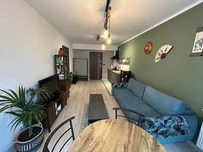 a living room with a blue couch and a table at Garden Spot and Parking in Kraków