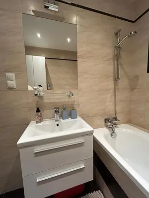 a bathroom with a sink and a tub and a mirror at Garden Spot and Parking in Kraków