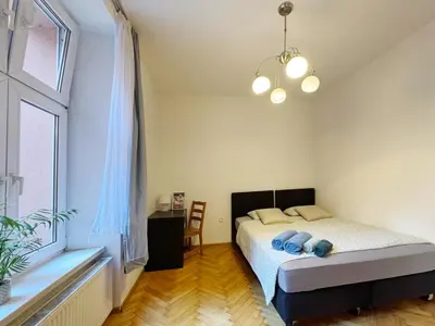 a bedroom with a bed and a large window at Starowislna loft - perfect for 6 people in Kraków