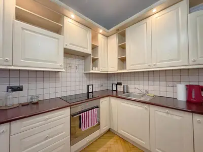 a kitchen with white cabinets and a sink at Starowislna loft - perfect for 6 people in Kraków