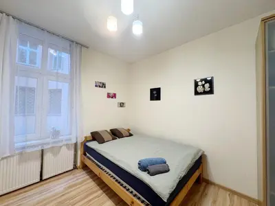 a bed in a room with a window at Starowislna loft - perfect for 6 people in Kraków