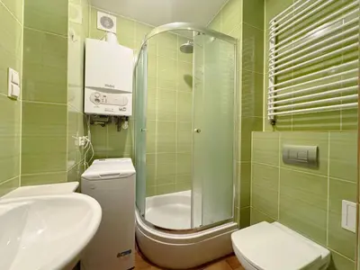 a green tiled bathroom with a toilet and a sink at Starowislna loft - perfect for 6 people in Kraków