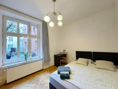a bedroom with a bed and a large window at Starowislna loft - perfect for 6 people in Kraków