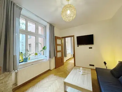 a living room with a couch and a window at Starowislna loft - perfect for 6 people in Kraków