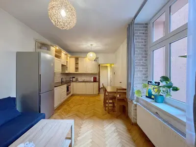 a kitchen with a stainless steel refrigerator and a table at Starowislna loft - perfect for 6 people in Kraków
