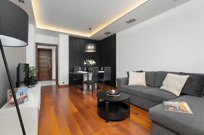 a living room with a couch and a table at Modern Apartment with Desk and Balcony by Noclegi Renters in Kraków