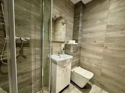 a bathroom with a toilet and a sink and a shower at Apartamenty Podlesie in Przeciszów