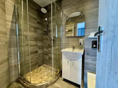 a bathroom with a shower and a sink at Apartamenty Podlesie in Przeciszów