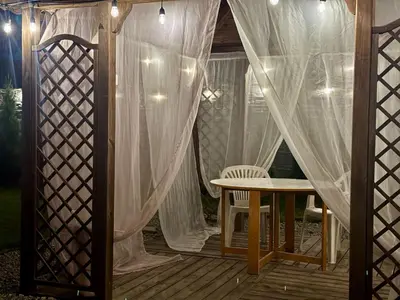 a screened in porch with a table and a curtain at Apartamenty Podlesie in Przeciszów
