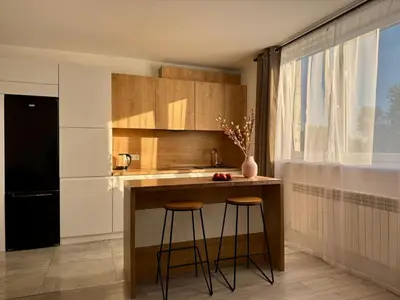 a kitchen with a counter and two stools at Apartamenty Podlesie in Przeciszów
